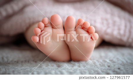 Sweet little feet of a child resting on a blanket Sweet little feet of a child resting on a blanket 127961577