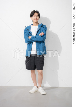 Young man in sportswear with arms crossed, looking up Young man in sportswear with arms crossed, looking up 127961678