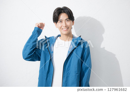 Young man in sportswear posing with fist pump, looking at camera 127961682