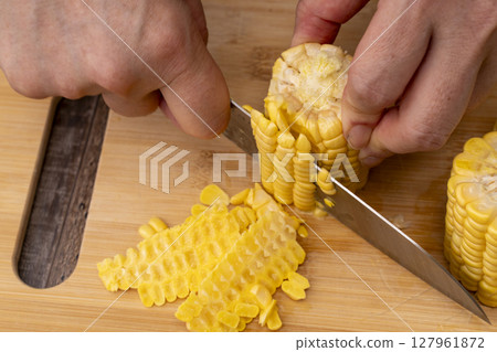 The process of making corn soup from freshly harvested corn: Removing the kernels 127961872