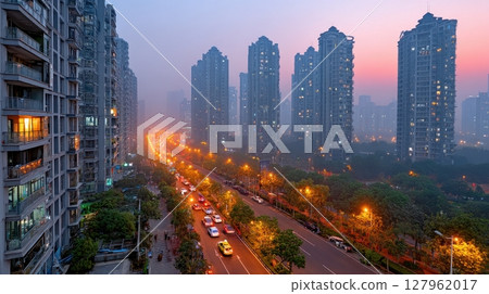 Aerial view: city lights, traffic. Tall buildings overlook busy street. Cityscape with modern architecture and urban life 127962017