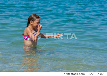 Caucasian happy and smiling child of 8 9 years closed her nose before diving and swimming Caucasian happy and smiling child of 8 9 years closed her nose before diving and swimming 127962365