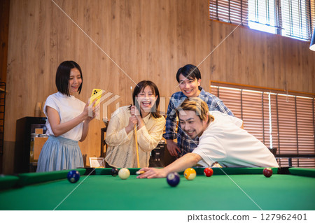 Friends enjoying billiards Friends enjoying billiards 127962401