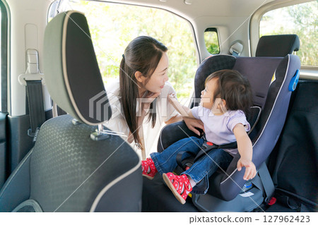媽媽把孩子放在汽車座椅上 媽媽把孩子放在汽車座椅上 127962423