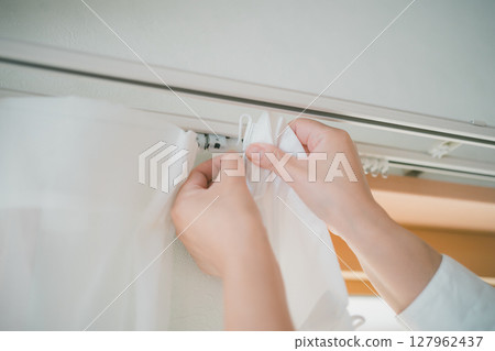 Put up lace curtains 127962437