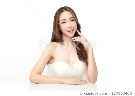 A beautiful young Asian woman with clean, fresh skin against a white background. Skincare, facial treatment, cosmetology, beauty, and spa. An elegant portrait of an Asian woman. A beautiful young Asian woman with clean, fresh skin against a white background. Skincare, facial treatment, cosmetology, beauty, and spa. An elegant portrait of an Asian woman. 127963460