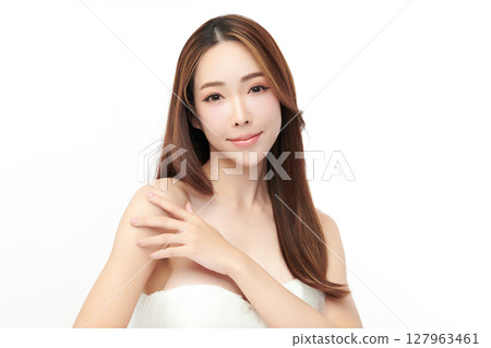 A beautiful young Asian woman with clean, fresh skin against a white background. Skincare, facial treatment, cosmetology, beauty, and spa. An elegant portrait of an Asian woman. 127963461