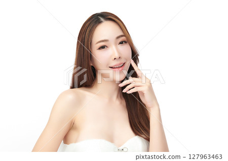 A beautiful young Asian woman with clean, fresh skin against a white background. Skincare, facial treatment, cosmetology, beauty, and spa. An elegant portrait of an Asian woman. 127963463