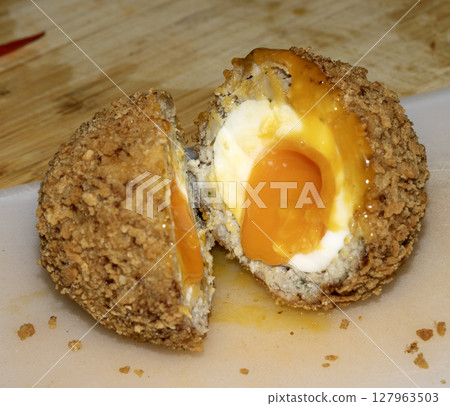 Crispy Scotch Egg Batter Fried Golden Close up with runny yolk 127963503