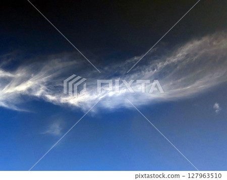 Close up of atmospheric blue black sky with whispy white clouds Close up of atmospheric blue black sky with whispy white clouds 127963510
