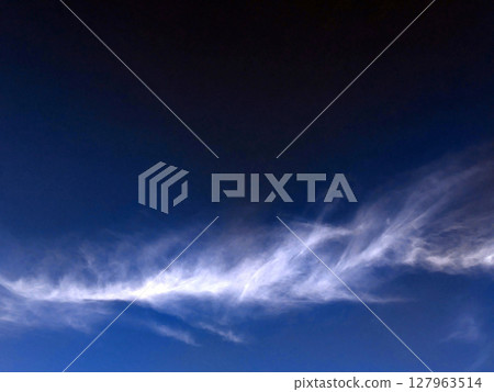 Close up of atmospheric blue black sky with whispy white clouds Close up of atmospheric blue black sky with whispy white clouds 127963514