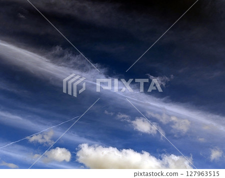 Close up of atmospheric blue black sky with whispy white clouds Close up of atmospheric blue black sky with whispy white clouds 127963515