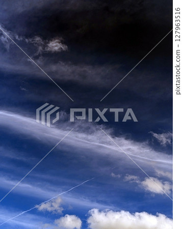 Close up of atmospheric blue black sky with whispy white clouds Close up of atmospheric blue black sky with whispy white clouds 127963516