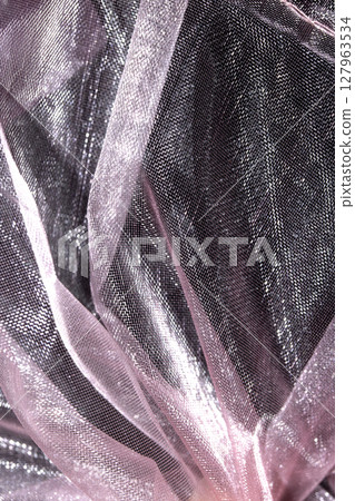 Close up of pink organza silk fabric in delicate waves for background Close up of pink organza silk fabric in delicate waves for background 127963534