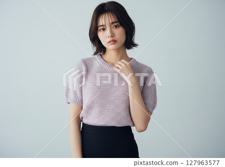 簡單的工作室背景，身穿淡紫色短袖針織和黑色裙子的女模特 127963577