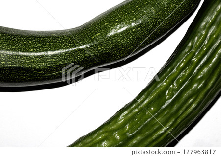 Close up of home grown cucumber courgette zucchini baby marrow vegetable skin green on white background Close up of home grown cucumber courgette zucchini baby marrow vegetable skin green on white background 127963817