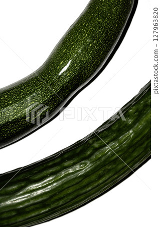 Close up of home grown cucumber courgette zucchini baby marrow vegetable skin green on white background Close up of home grown cucumber courgette zucchini baby marrow vegetable skin green on white background 127963820