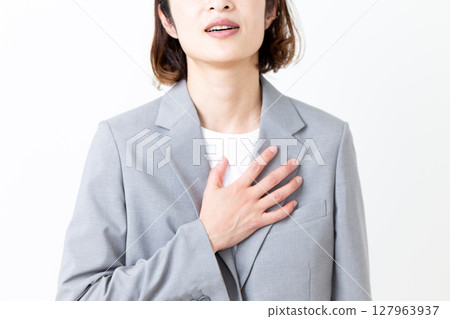 A middle-aged woman in a suit suffering from chest pain A middle-aged woman in a suit suffering from chest pain 127963937