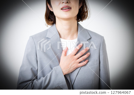 A middle-aged woman in a suit suffering from chest pain 127964067