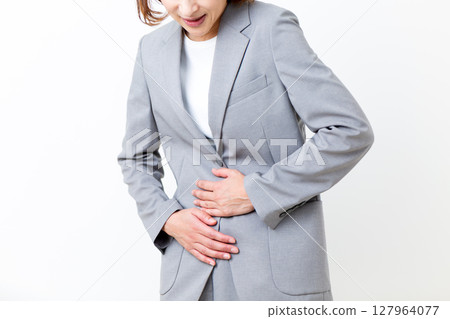 一名身著西裝的中年婦女因胃痛 一名身著西裝的中年婦女因胃痛 127964077