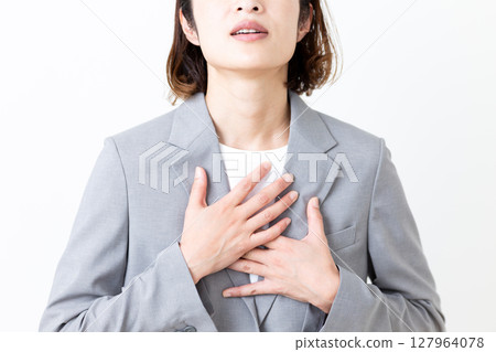 A middle-aged woman in a suit suffering from chest pain 127964078