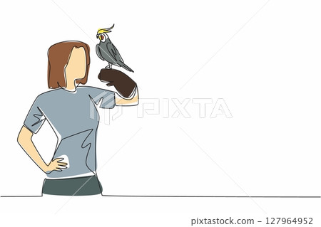 Single one line drawing grey cockatiel perched on hand of woman. Bird with characteristic crest on its head. A gentle and loving animal. Woman Holding Bird. Continuous line design graphic illustration 127964952