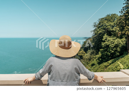 Female Explorer Looking at Ocean Horizon from Cliff 127965605