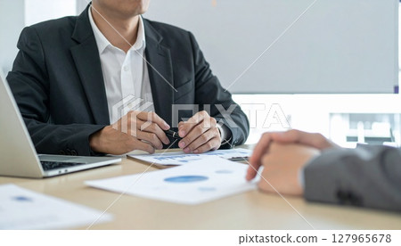 Business person holding a pen and listening 127965678
