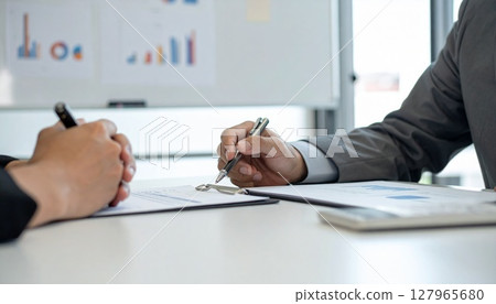 Business person holding a pen and listening 127965680