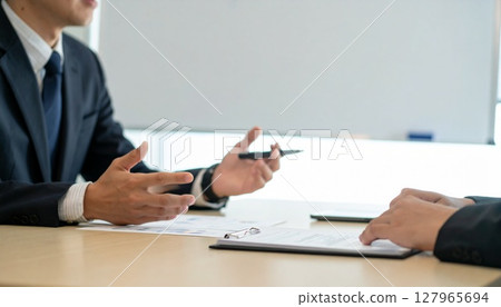 Business person holding a pen and listening 127965694