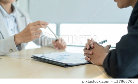 Business person holding a pen and listening 127965703