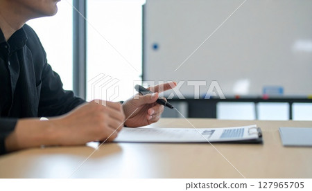 Business person holding a pen and listening 127965705