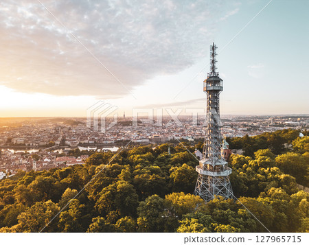 Golden light bathes Petrin Lookout Tower as the sun rises over Prague. Surrounded by lush greenery and the city skyline, this moment captures the beauty of early morning tranquility. Golden light bathes Petrin Lookout Tower as the sun rises over Prague. Surrounded by lush greenery and the city skyline, this moment captures the beauty of early morning tranquility. 127965715