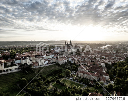 The sunrise casts a golden glow over Prague Castle and the surrounding city, showcasing the stunning architecture and serene atmosphere of early morning in Prague. The sunrise casts a golden glow over Prague Castle and the surrounding city, showcasing the stunning architecture and serene atmosphere of early morning in Prague. 127965716