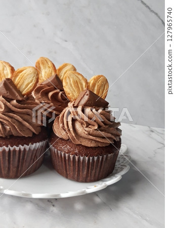 Moist and rich chocolate cupcake topped with creamy chocolate frosting. A delightful bite-sized treat for every chocolate lover. Moist and rich chocolate cupcake topped with creamy chocolate frosting. A delightful bite-sized treat for every chocolate lover. 127965740