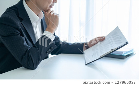 A business person nodding while looking at a contract 127966052