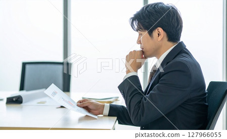 A business person nodding while looking at a contract 127966055