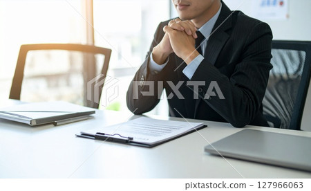 A business person nodding while looking at a contract 127966063