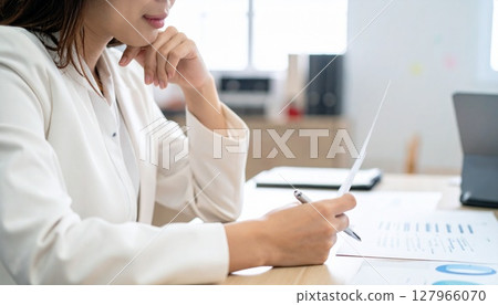 A business person nodding while looking at a contract 127966070