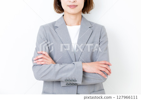 一位身穿灰色西裝、雙臂交叉的中年婦女 127966111