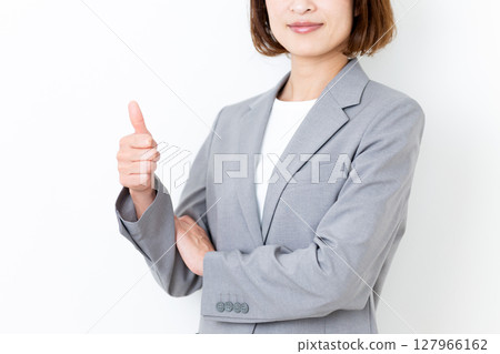 一位身穿灰色西裝的中年婦女豎起了大拇指 127966162