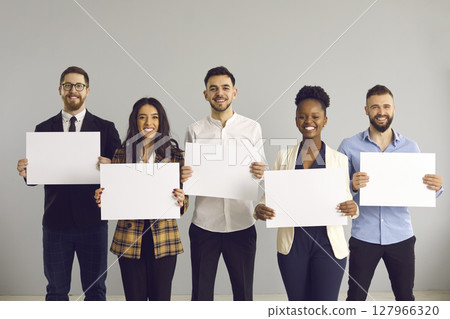 Multi-ethnic diverse business team holding empty paper sheets studio portrait Multi-ethnic diverse business team holding empty paper sheets studio portrait 127966320