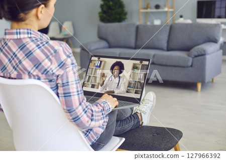 Young woman with laptop computer video calling online doctor of telemedicine clinic 127966392