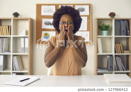 Shocked african american woman showing surprise wow expression looking at camera 127966412