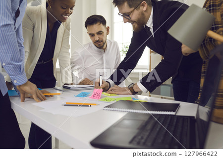 Creative manager writing with market on sticker idea note for team project 127966422