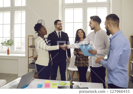 Business team colleagues shaking hands while working in creative office Business team colleagues shaking hands while working in creative office 127966455