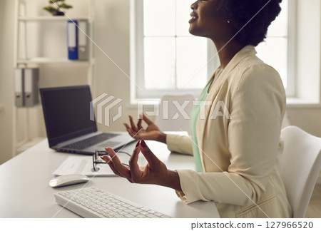 African american employee keep calm meditating at office desk cropped portrait 127966520