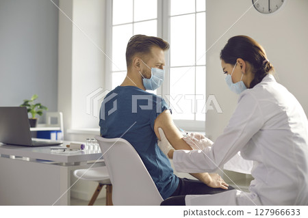 Young patient getting vaccine during seasonal vaccination campaign at the clinic 127966633