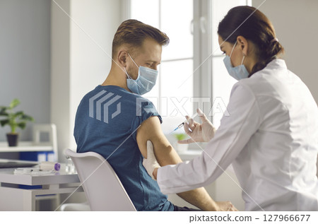 Male patient getting injection vaccination from nurse in clinic Male patient getting injection vaccination from nurse in clinic 127966677