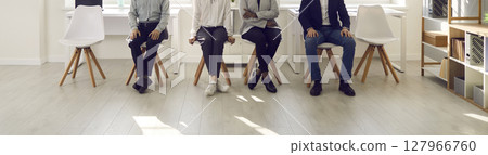 Cropped image of the legs of various people sitting on chairs and waiting their turn. Cropped image of the legs of various people sitting on chairs and waiting their turn. 127966760